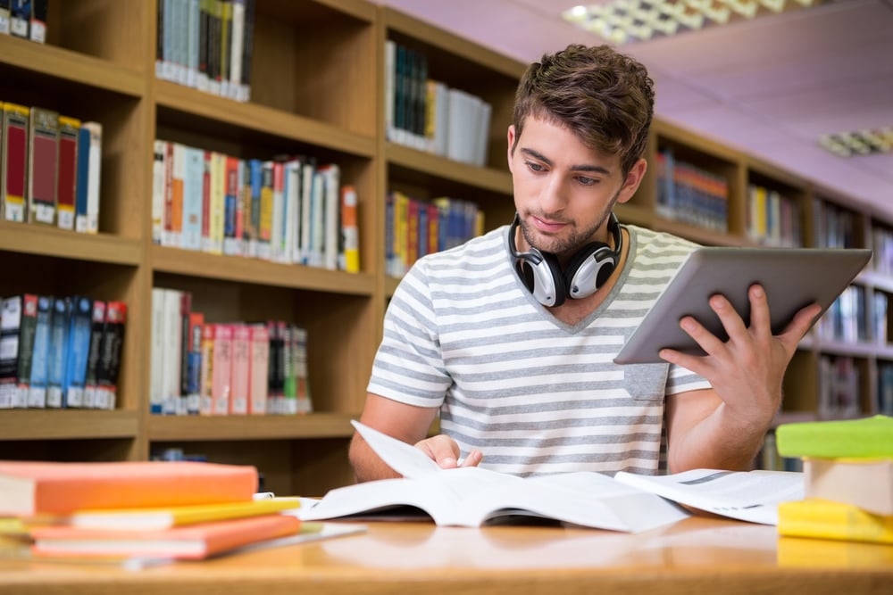 Student studying in the library with tablet at the university Student studying in the library with tablet at the university